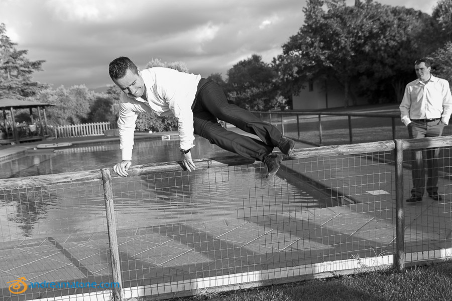 The groom jumping over the fence.