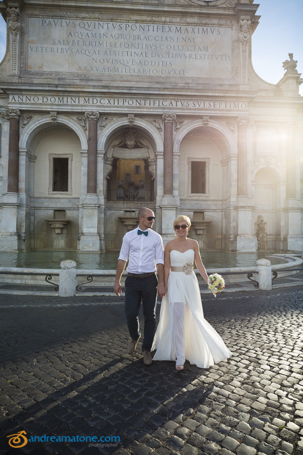 Bride and groom crossing the street at the Gianicolo water fountain