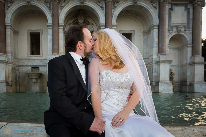 Couple kissing in front of the Gianicolo water fountain.