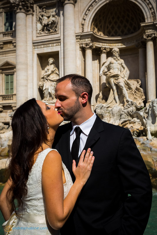 Newlyweds kissing at the Trevi fountain. Rome Destination Wedding Photographer.