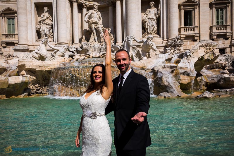 Wedding couple throwing the coin into the water fountain at Piazza Fontana di Trevi.