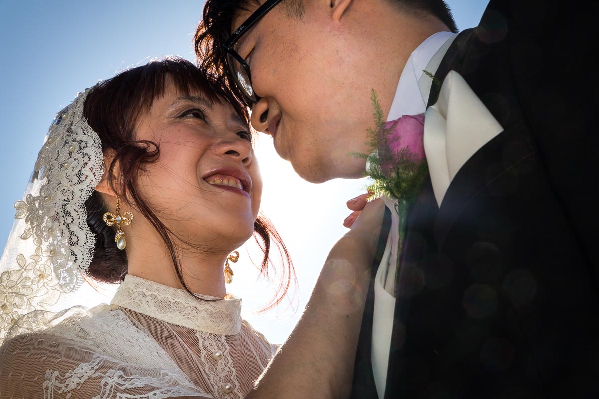 Close up photo of the newlyweds against blue sky