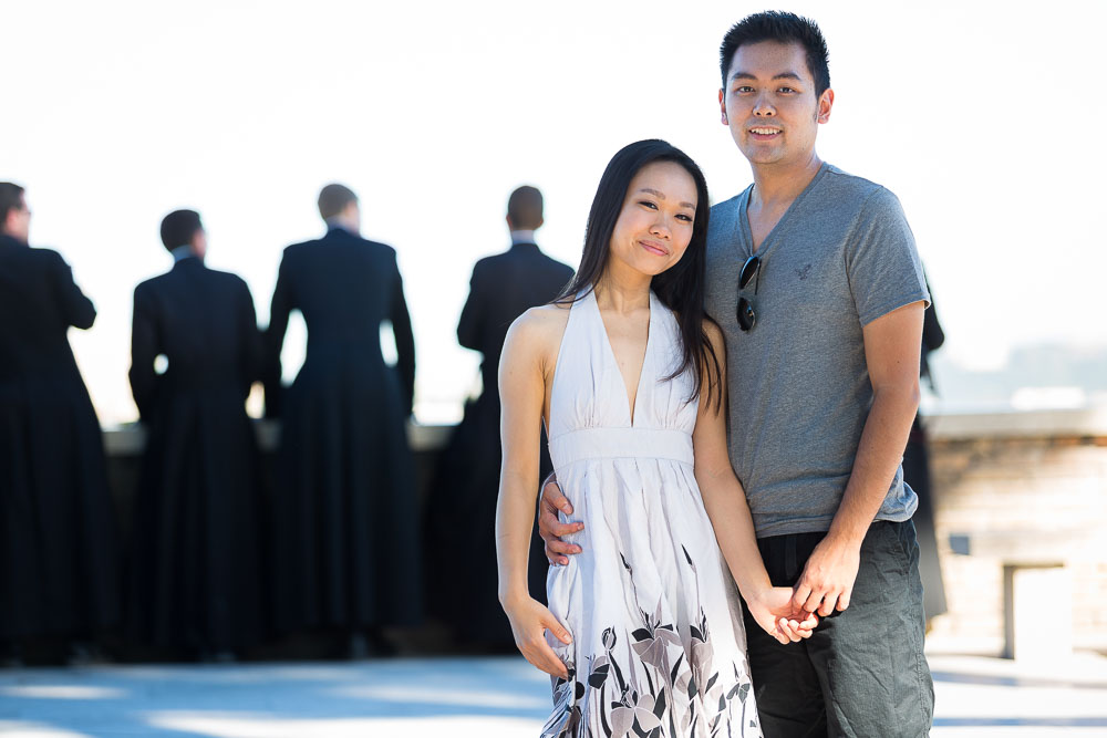Couple portrait picture with out of focus priests in the background