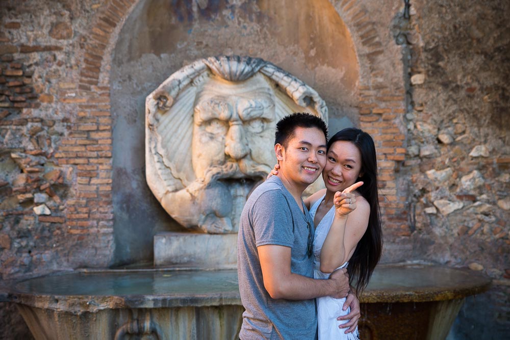 Portrait picture of a couple posing in front of the water fountain in Parco degli Aranci