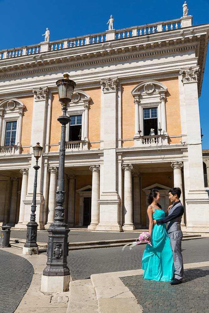 Couple photographed in Piazza del Campidoglio during a prewedding session. Building architecture.