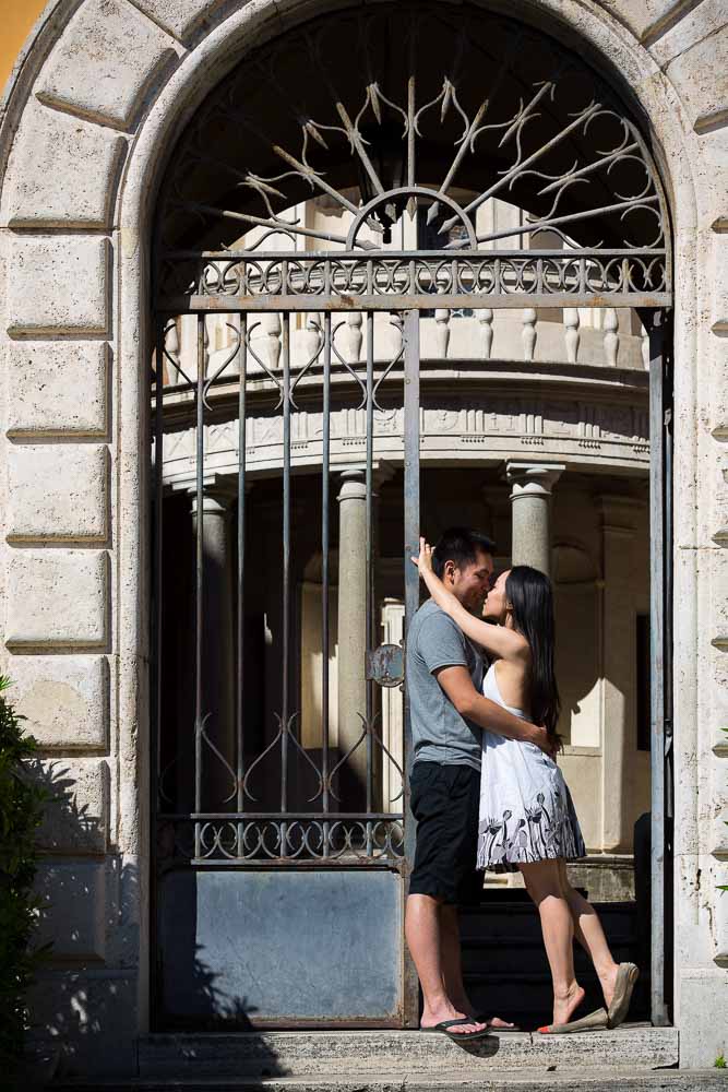 Engaged couple posing in front of a cloister.