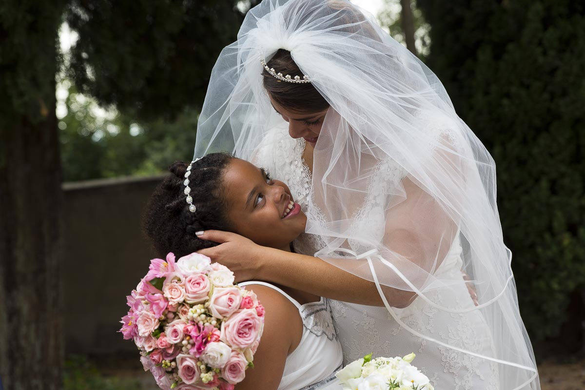 Bride with a flower girl. Touching moment.