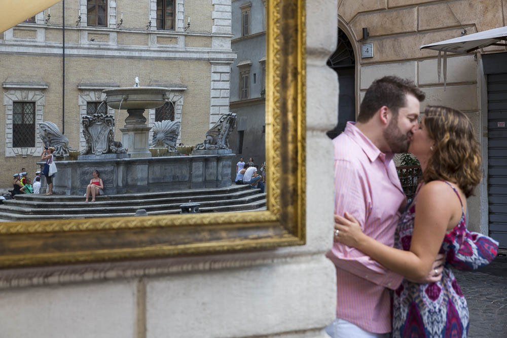 Engaged couple reflected in a mirror at Piazza Trastevere in Rome Italy.