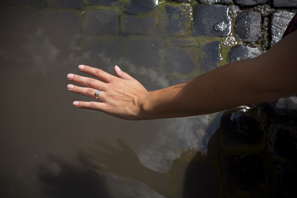 Hand over a puddle white the ring is photographed.