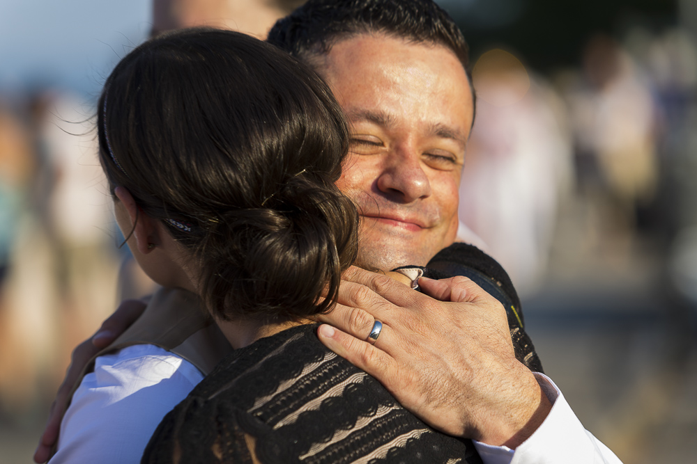 The groom embracing the celebrant.