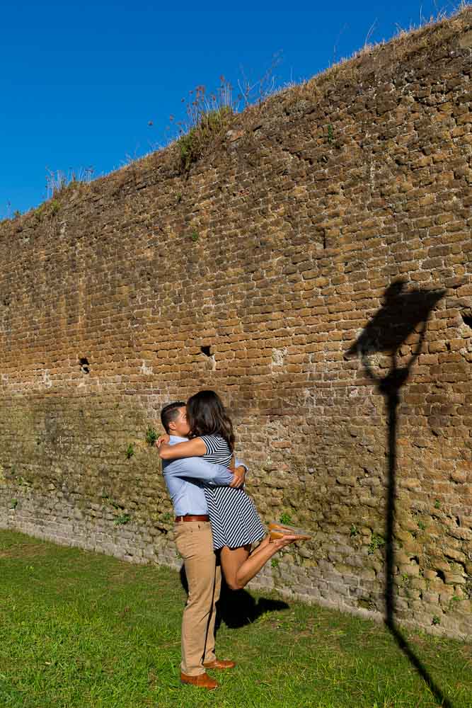 Embracing each other next to light pole shadow on the wall. Artistic image.