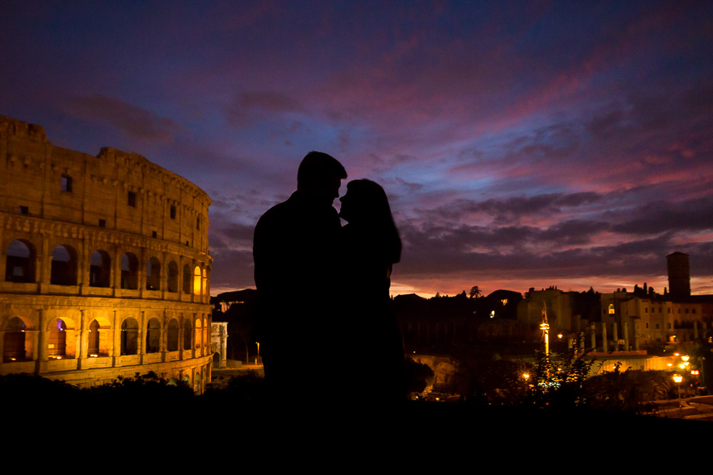 Silhouette figures in the dark in front of the Coliseum 