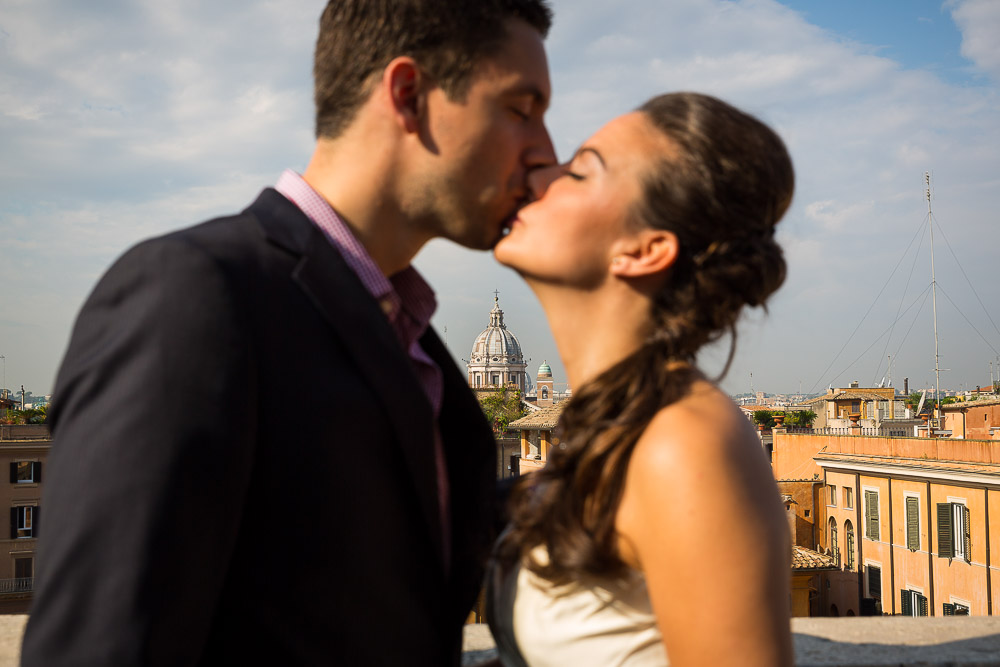 Couple kissing during a photo shoot overlooking the roman rooftops at Trinita' dei Monti.