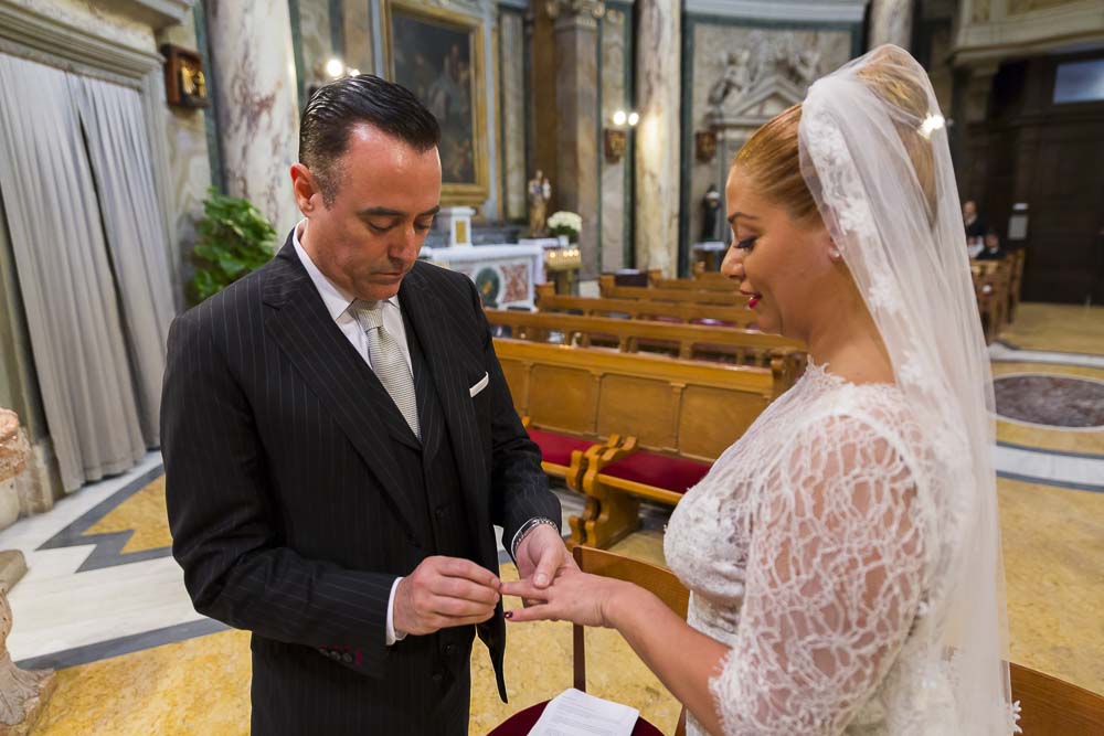 Groom putting the ring on the bridge during the wedding ceremony in Santa Anna Church.