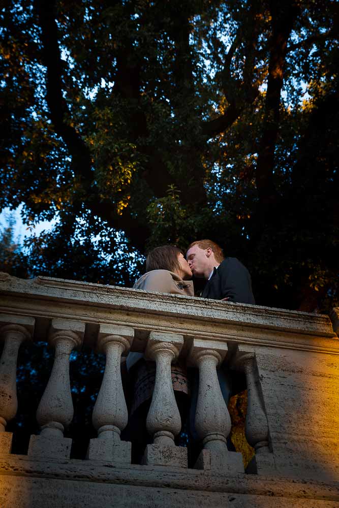 Romantic image of a couple kissing at a terrace view.