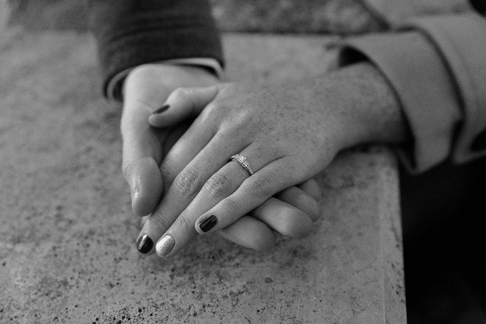 Black and white image of the engagement ring on the hand