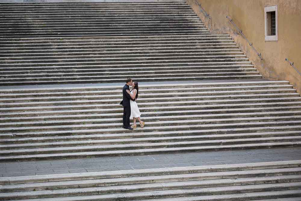 Couple photographed from afar at the Campidoglio square. Honeymoon photography service.