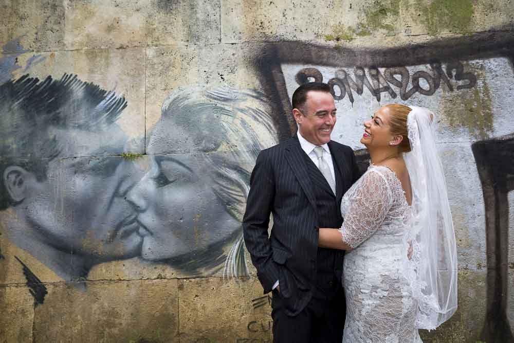 Wedding pictures taken down the tiber river with some graffiti in the background.