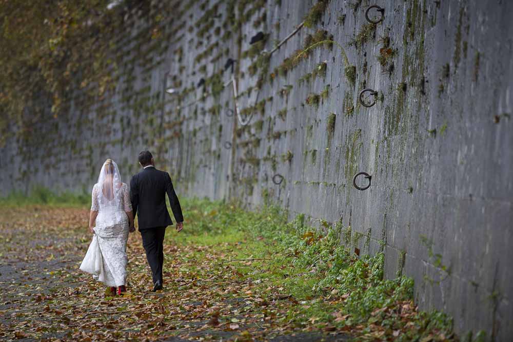 Walking away hand in hand on the Tiber river bank.