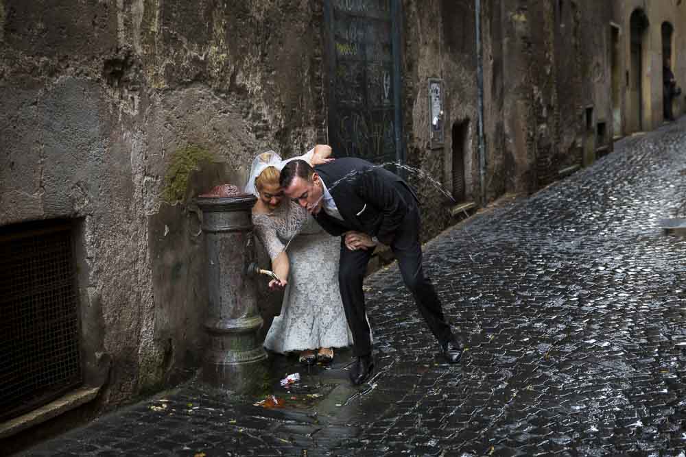 Drinking from a water fountain in the streets of the ancient city. Cobble stones.