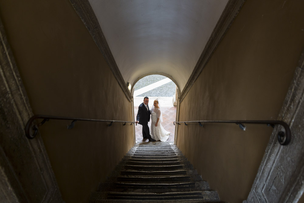 View of groom and bride inside a staircase tunnel.