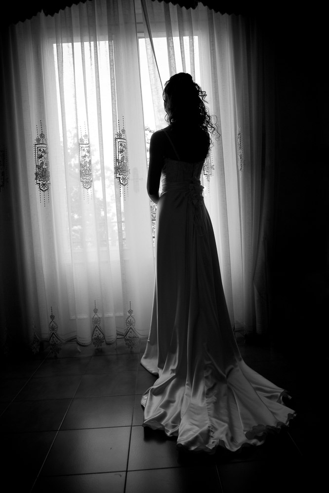 Bride looking at the window. Black and white picture.