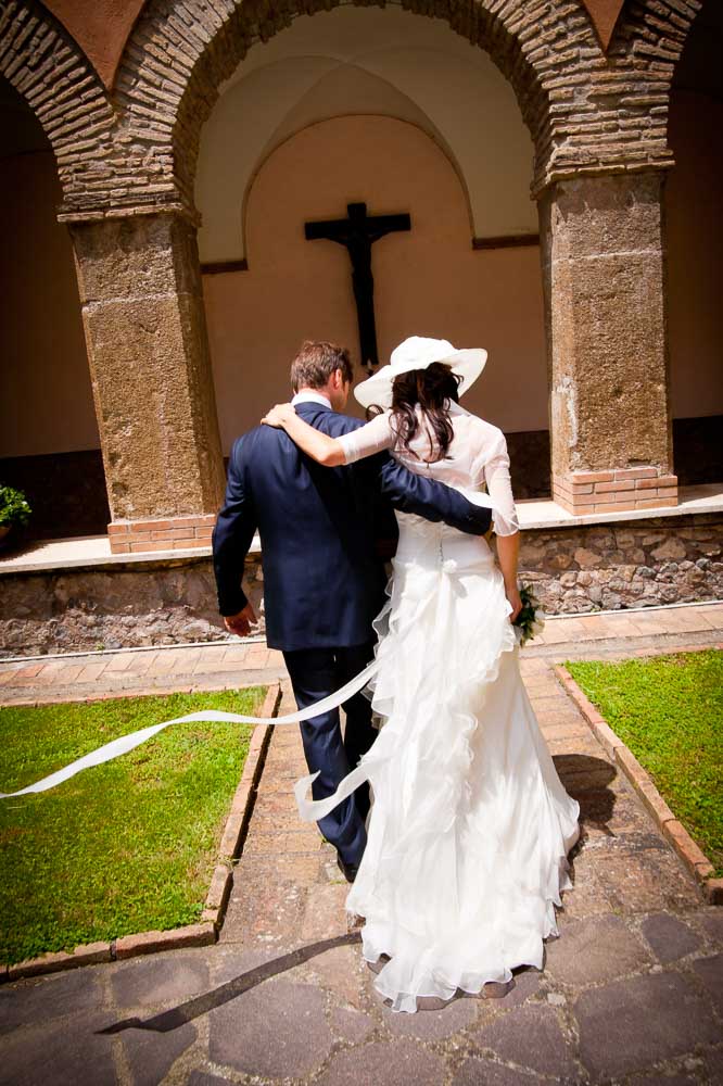 Italian catholic wedding. Bride and groom walk towards the Church.