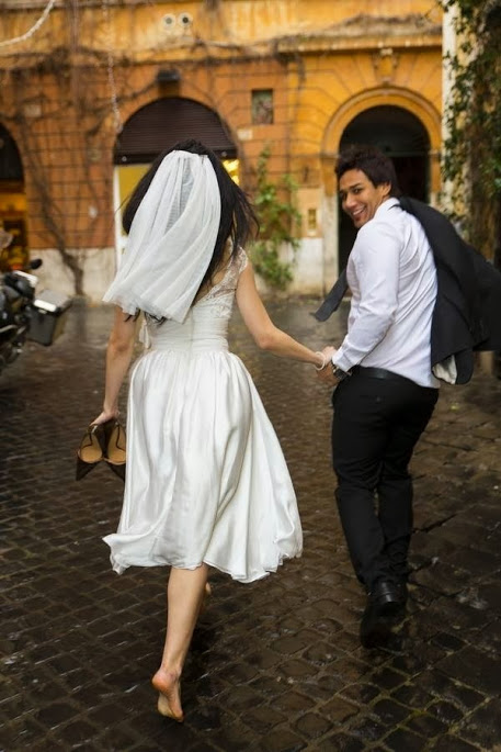 Bride and groom running under rain during their wedding day