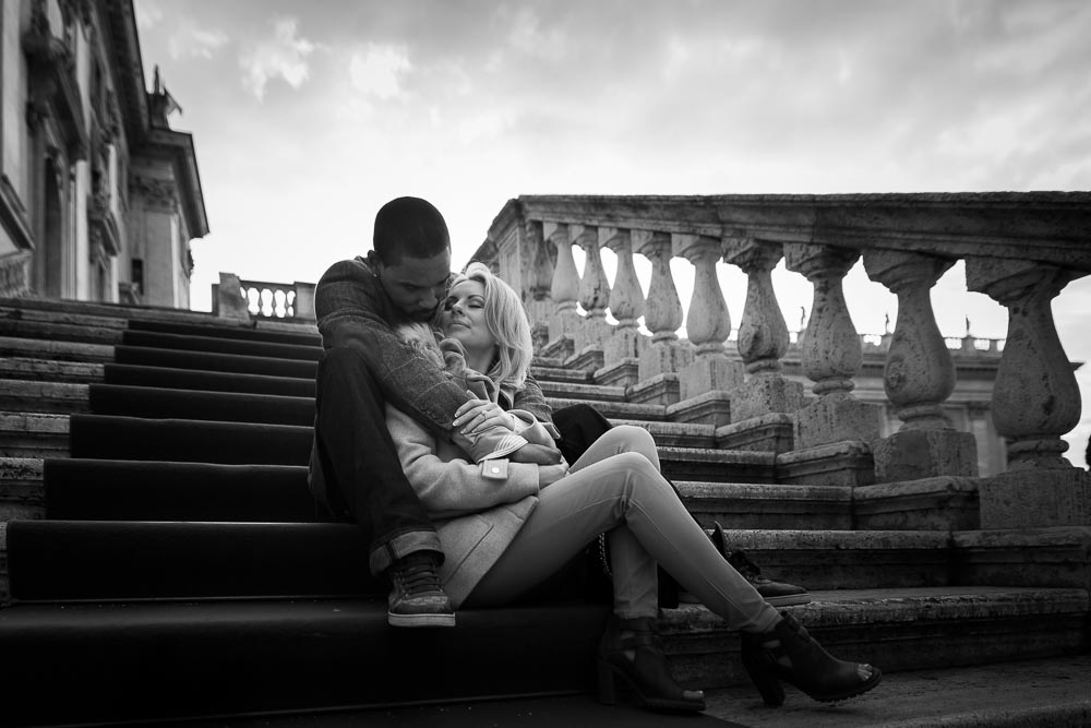 Black & white picture of a couple in love in Rome. Sitting down on steps. 