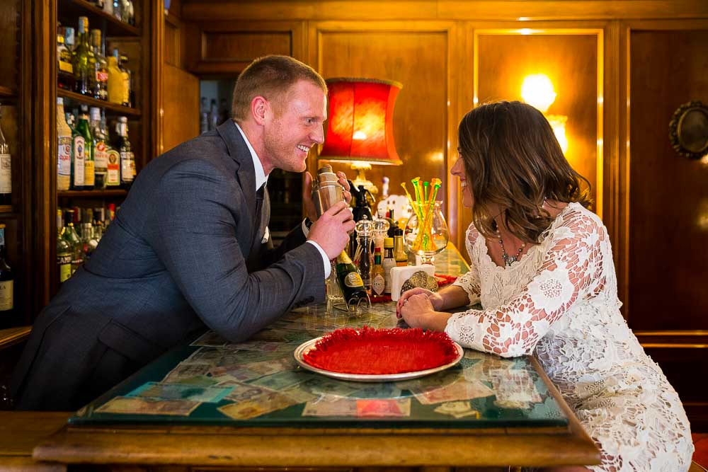 Playful image of a couple about to get married taking pictures at a Hotel bar