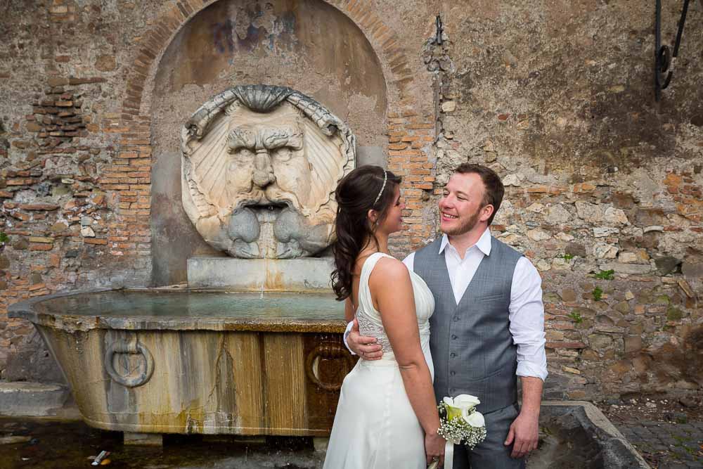 Newlyweds outside Giardino Aranci park in front of a water fountain