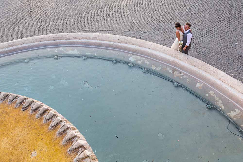 Just married coupe next to a water fountain in Piazza del Popolo