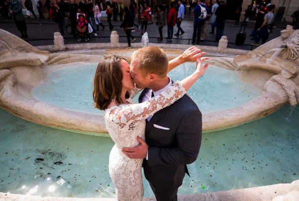 Couple in love in Rome after a wedding celebration. Photographed by the Barcaccia water fountain.