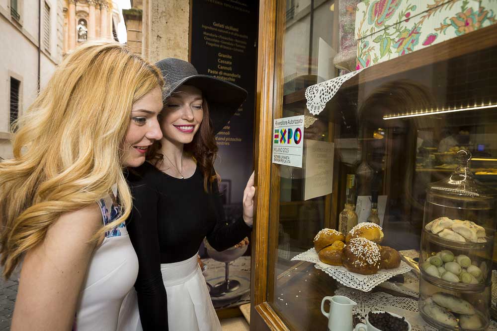 Girl friends photoshoot looking into a showcase in Rome Italy. Lifestyle photography session.