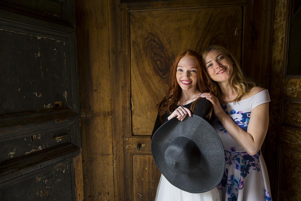 Posing inside a wooden door by a church with sun light shining from the sides