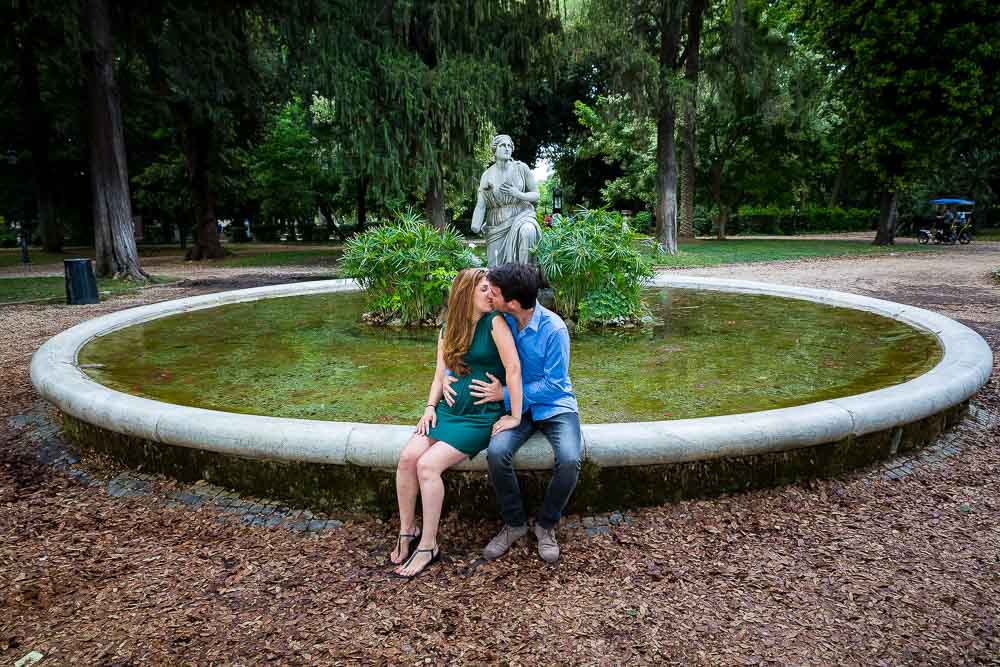 Couple picture sitting down at the border of a water fountain in Villa Borghese