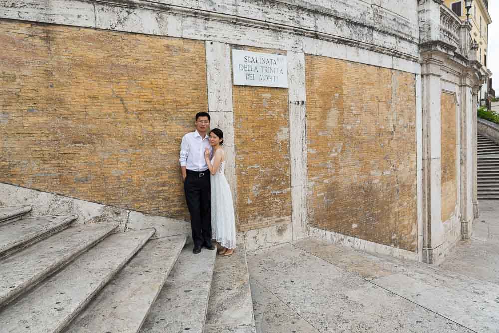 Bride and groom standing on the Spanish steps taking pictures 