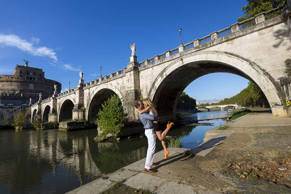 Man picking up fiancee during a photo shoot underneath the Castel Sant'Angelo bridge