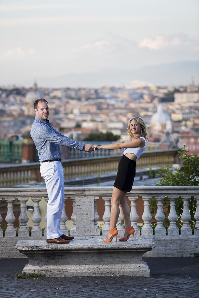 Standing on a marble bench during and engagement session in Rome