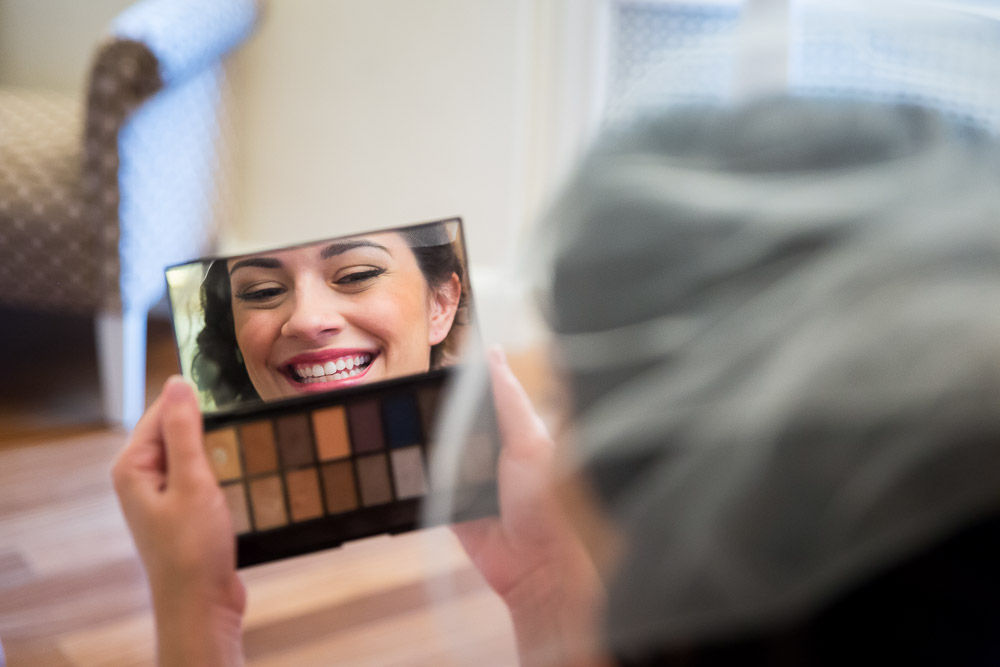 Woman with veil looking through the makeup mirror