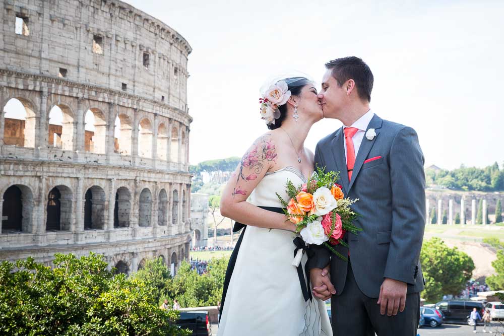 Groom and bride at the Colosseum kissing