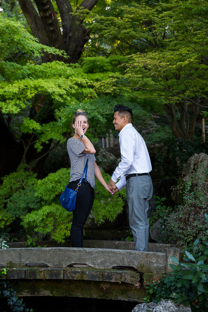 Happiness and surprise on a wooden bridge in the Japanese garden in the Botanic park