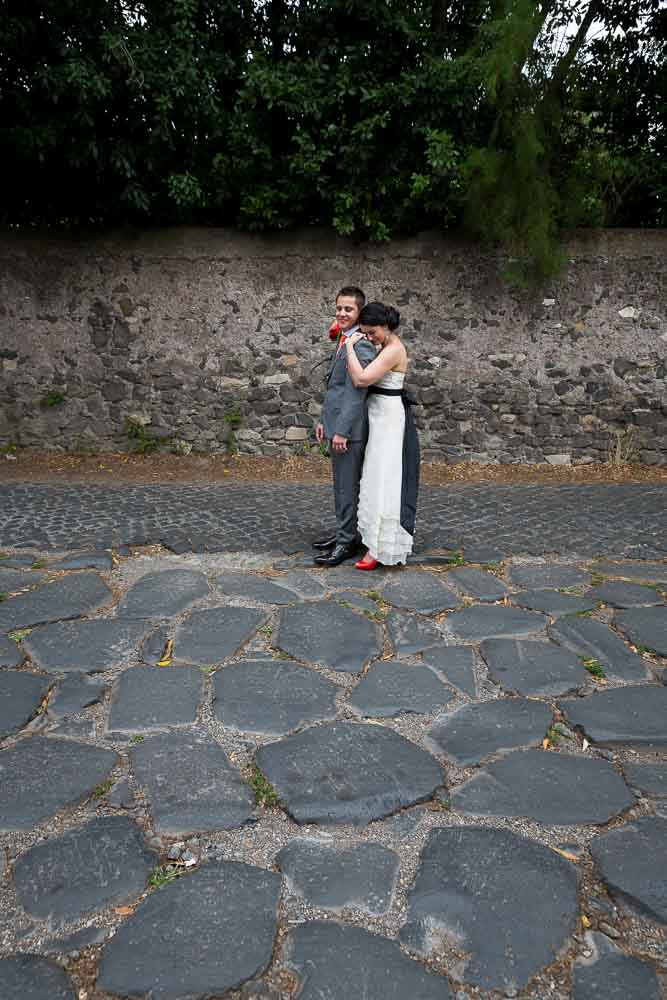 Newlyweds standing on the ancient Appian roman road