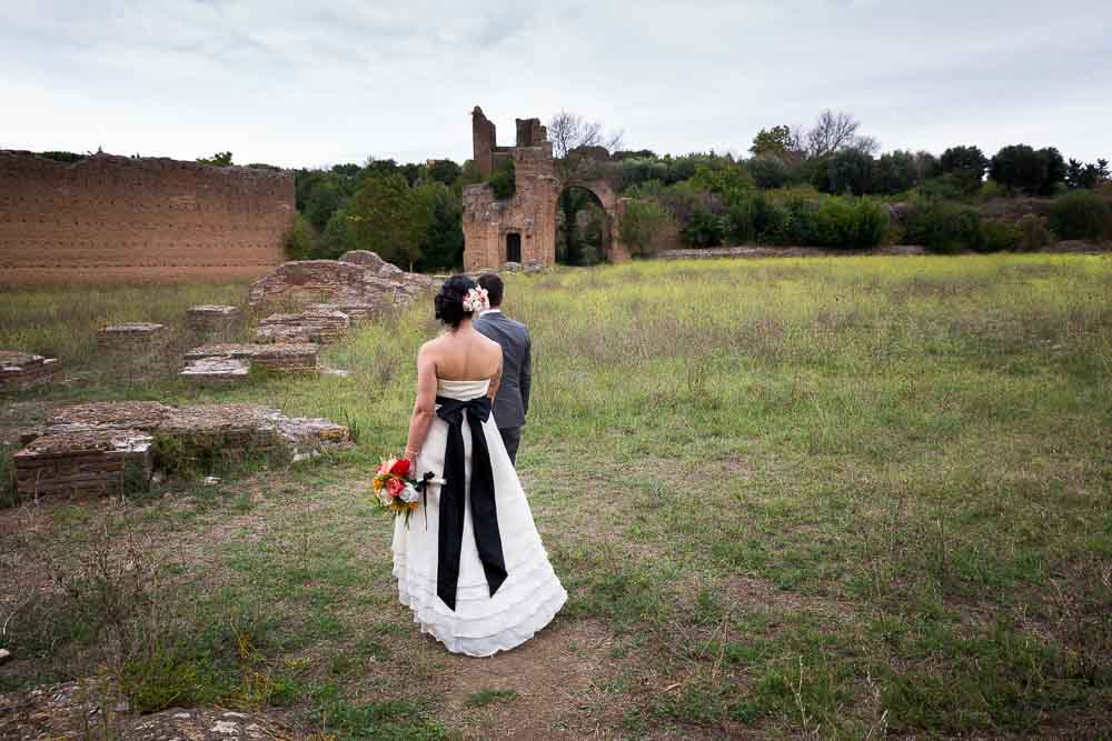Married couple walking together among ancient roman ruins during a photography session in Rome Italy