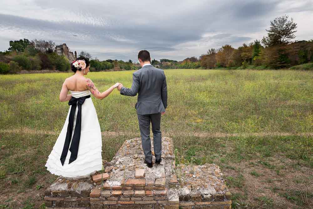 Holding on to each other's hand in a field after a wedding