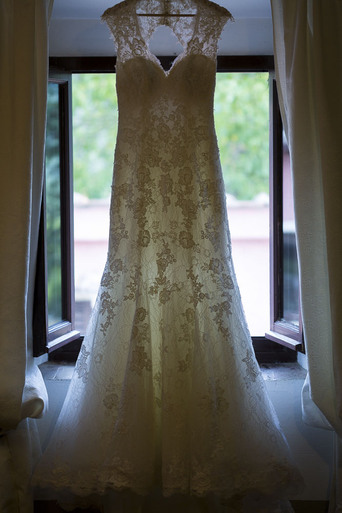 The wedding dress hanging from the window 