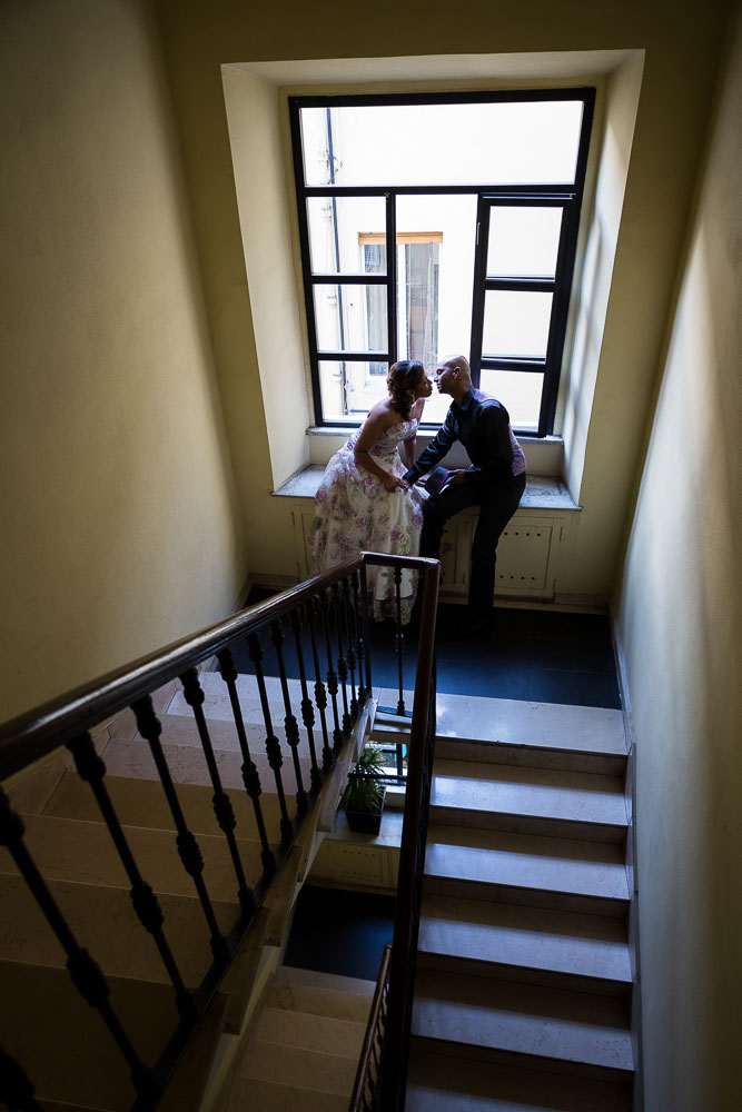 Picture of a couple sitting down on a staircase romantically kissing