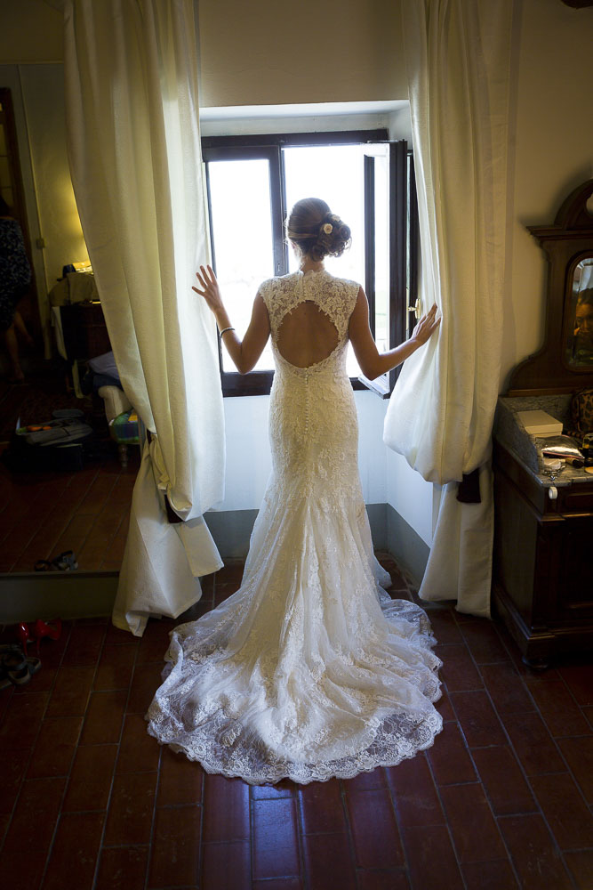 Looking out of the window wearing the wedding dress