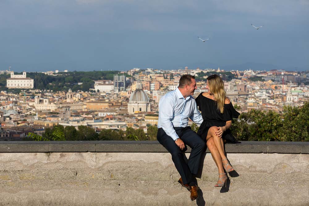 Sitting down on a wall in front of the sweeping view over the roman rooftops in Rome Italy.