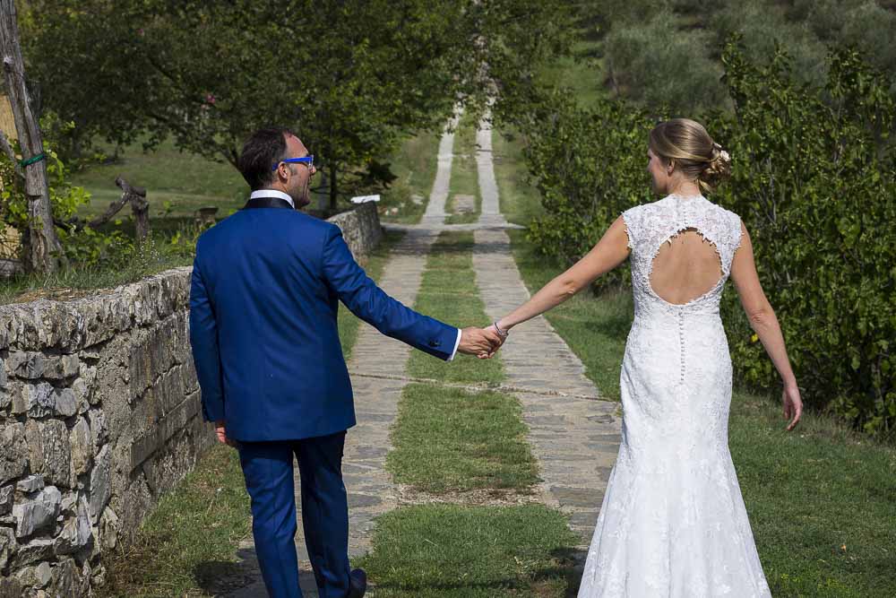 Newlywed couple walking together holding hand in hand. Wedding in Tuscany Italy